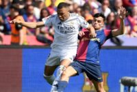 Mbappe pergi ke bola melawan Pedri dalam pertandingan Real kalah dari Barca 3-4 di babak ke-35 La Liga pada 11/5/2025. Foto: AFP