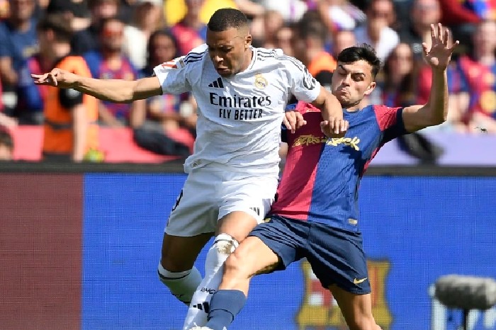 Mbappe pergi ke bola melawan Pedri dalam pertandingan Real kalah dari Barca 3-4 di babak ke-35 La Liga pada 11/5/2025. Foto: AFP